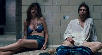 Movie still from “Choke” (2008), directed by Clark Gregg – A woman sitting on the ground next to a man; Medium shot, High angle