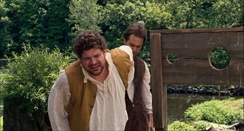 Movie still from “Choke” (2008), directed by Clark Gregg – Two men in medieval garb standing next to each other in a wooded area; Medium shot, Over the shoulder angle