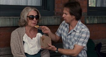 Movie still from “Choke” (2008), directed by Clark Gregg – A man and a woman sitting on a bench eating pizza; Medium shot, Over the shoulder angle
