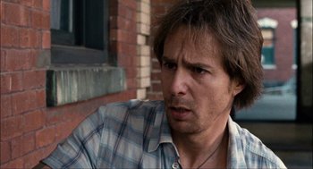 Movie still from “Choke” (2008), directed by Clark Gregg – A person wearing a plaid shirt; Close Up shot, Over the shoulder angle