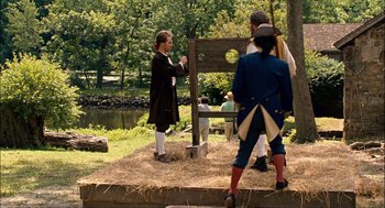 Movie still from “Choke” (2008), directed by Clark Gregg – A group of people standing next to each other on a field; Wide shot, Over the shoulder angle