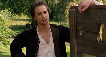 Movie still from “Choke” (2008), directed by Clark Gregg – A man standing next to a wooden fence; Medium shot, Over the shoulder angle