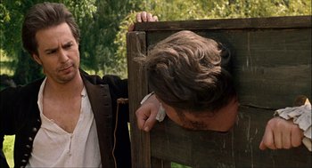 Movie still from “Choke” (2008), directed by Clark Gregg – Two men are standing next to each other; Medium shot, Over the shoulder angle