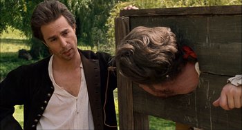 Movie still from “Choke” (2008), directed by Clark Gregg – A man in a white shirt is looking at another man; Close Up shot, Over the shoulder angle