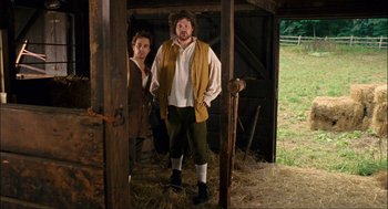 Movie still from “Choke” (2008), directed by Clark Gregg – A man and a woman standing next to each other; Medium shot, Low angle