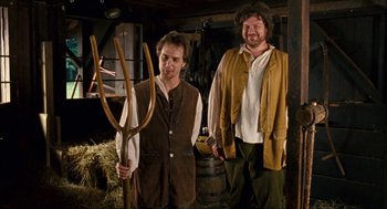 Movie still from “Choke” (2008), directed by Clark Gregg – Two men dressed in medieval clothing holding a wooden fork; Medium shot, High angle