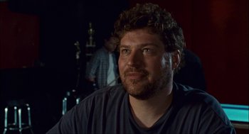 Movie still from “Choke” (2008), directed by Clark Gregg – A person sitting in a room; Close Up shot, Over the shoulder angle