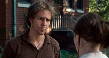 Movie still from “Choke” (2008), directed by Clark Gregg – A young man is looking at a woman outside; Close Up shot, Over the shoulder angle