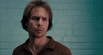 Movie still from “Choke” (2008), directed by Clark Gregg – A person wearing a brown shirt; Close Up shot, Low angle