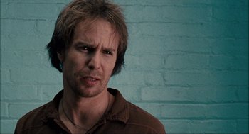 Movie still from “Choke” (2008), directed by Clark Gregg – A person wearing a brown shirt; Close Up shot, Low angle