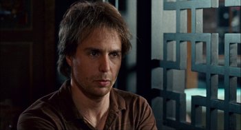 Movie still from “Choke” (2008), directed by Clark Gregg – A person wearing a brown shirt; Close Up shot, Low angle