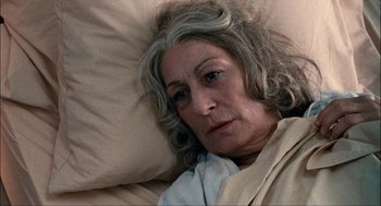 Movie still from “Choke” (2008), directed by Clark Gregg – An older woman laying in a bed with her head on a pillow; Close Up shot, High angle