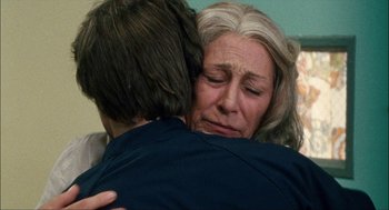 Movie still from “Choke” (2008), directed by Clark Gregg – A woman is hugging another woman in a room; Close Up shot, Over the shoulder angle