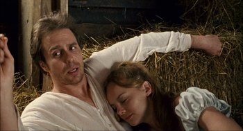 Movie still from “Choke” (2008), directed by Clark Gregg – A man and a woman laying in a pile of hay; Medium shot, Low angle