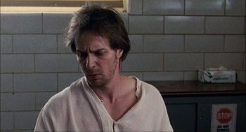 Movie still from “Choke” (2008), directed by Clark Gregg – A man in a white shirt is looking down; Close Up shot, Over the shoulder angle