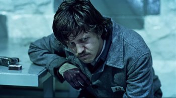 Movie still from “Chopper” (2000), directed by Andrew Dominik – A man with a bloody hand on his shoulder; Medium shot, High angle