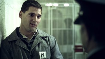 Movie still from “Chopper” (2000), directed by Andrew Dominik – A man in a gray jacket is looking at the camera; Close Up shot, Over the shoulder angle