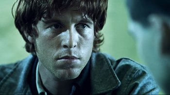 Movie still from “Chopper” (2000), directed by Andrew Dominik – A person wearing a jacket; Close Up shot, Over the shoulder angle