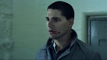 Movie still from “Chopper” (2000), directed by Andrew Dominik – A young man with a shaved head and a beard; Close Up shot, Low angle