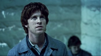 Movie still from “Chopper” (2000), directed by Andrew Dominik – A man in a jacket looking up at the sky; Close Up shot, Low angle