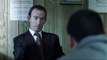 Movie still from “Chopper” (2000), directed by Andrew Dominik – A man wearing a suit and tie in front of a mirror; Close Up shot, Over the shoulder angle