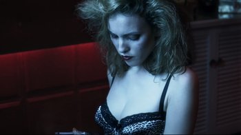 Movie still from “Chopper” (2000), directed by Andrew Dominik – A woman in a black and white bra looking at a cell phone; Close Up shot, Overhead angle