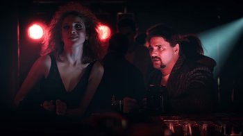 Movie still from “Chopper” (2000), directed by Andrew Dominik – A man and a woman sitting at a bar; Medium shot, Low angle