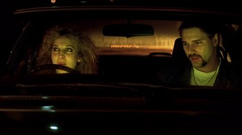 Movie still from “Chopper” (2000), directed by Andrew Dominik – A man and a woman in the back seat of a car; Medium shot, Low angle