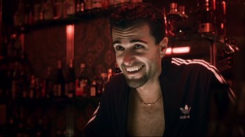 Movie still from “Chopper” (2000), directed by Andrew Dominik – A man smiling at the camera while sitting at a bar; Close Up shot, Low angle