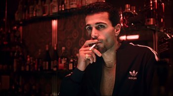 Movie still from “Chopper” (2000), directed by Andrew Dominik – A man smoking a cigarette in front of a bar; Close Up shot, Low angle