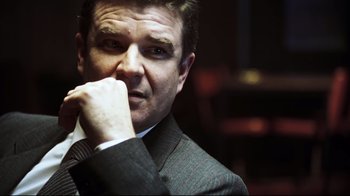 Movie still from “Chopper” (2000), directed by Andrew Dominik – A person wearing a suit and tie; Close Up shot, Over the shoulder angle