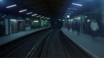Movie still from “Christiane F.” (1981), directed by Uli Edel – People are waiting for the train at a train station at night; Extreme Wide shot, High angle