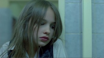 Movie still from “Christiane F.” (1981), directed by Uli Edel – A young girl sitting in front of a tiled wall; Close Up shot, High angle