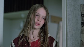 Movie still from “Christiane F.” (1981), directed by Uli Edel – A young girl with long brown hair looking at the camera; Close Up shot, Low angle