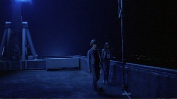 Movie still from “Christiane F.” (1981), directed by Uli Edel – A couple of people standing on top of a building; Wide shot, High angle