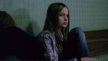 Movie still from “Christiane F.” (1981), directed by Uli Edel – A girl sitting on the ground in a room; Medium shot, High angle