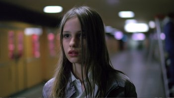 Movie still from “Christiane F.” (1981), directed by Uli Edel – A young girl with long brown hair standing in a hallway; Close Up shot, Low angle