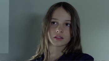 Movie still from “Christiane F.” (1981), directed by Uli Edel – A young girl with long brown hair looking at the camera; Close Up shot, Low angle