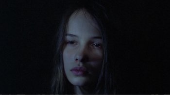 Movie still from “Christiane F.” (1981), directed by Uli Edel – A woman with long dark hair is looking at the camera; Close Up shot, High angle