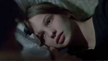 Movie still from “Christiane F.” (1981), directed by Uli Edel – A girl laying in a bed with her head resting on a pillow; Close Up shot, High angle