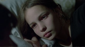 Movie still from “Christiane F.” (1981), directed by Uli Edel – A young girl laying in a bed with her head on a pillow; Close Up shot, High angle