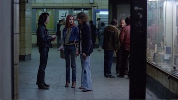 Movie still from “Christiane F.” (1981), directed by Uli Edel – A group of people standing around in a subway station; Wide shot, Over the shoulder angle