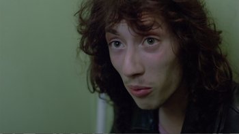 Movie still from “Christiane F.” (1981), directed by Uli Edel – A person with curly brown hair; Close Up shot, High angle