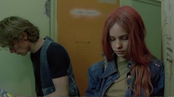 Movie still from “Christiane F.” (1981), directed by Uli Edel – A girl with red hair and a man standing next to a door; Medium shot, Over the shoulder angle