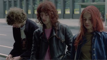 Movie still from “Christiane F.” (1981), directed by Uli Edel – A group of young people sitting on a bench; Medium shot, High angle