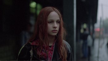 Movie still from “Christiane F.” (1981), directed by Uli Edel – A girl with red hair is looking at the camera; Close Up shot, Over the shoulder angle