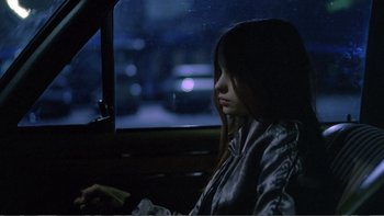Movie still from “Christiane F.” (1981), directed by Uli Edel – A woman sitting in a car looking out the window at night; Medium shot, High angle