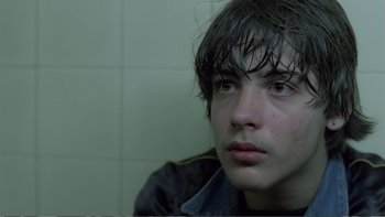 Movie still from “Christiane F.” (1981), directed by Uli Edel – A man with wet hair sitting in a bathroom; Close Up shot, Over the shoulder angle