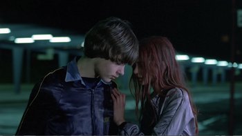 Movie still from “Christiane F.” (1981), directed by Uli Edel – A boy and a girl standing next to each other; Close Up shot, Over the shoulder angle