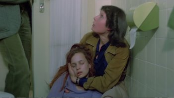 Movie still from “Christiane F.” (1981), directed by Uli Edel – A woman and a girl sitting next to each other in a bathroom; Medium shot, High angle